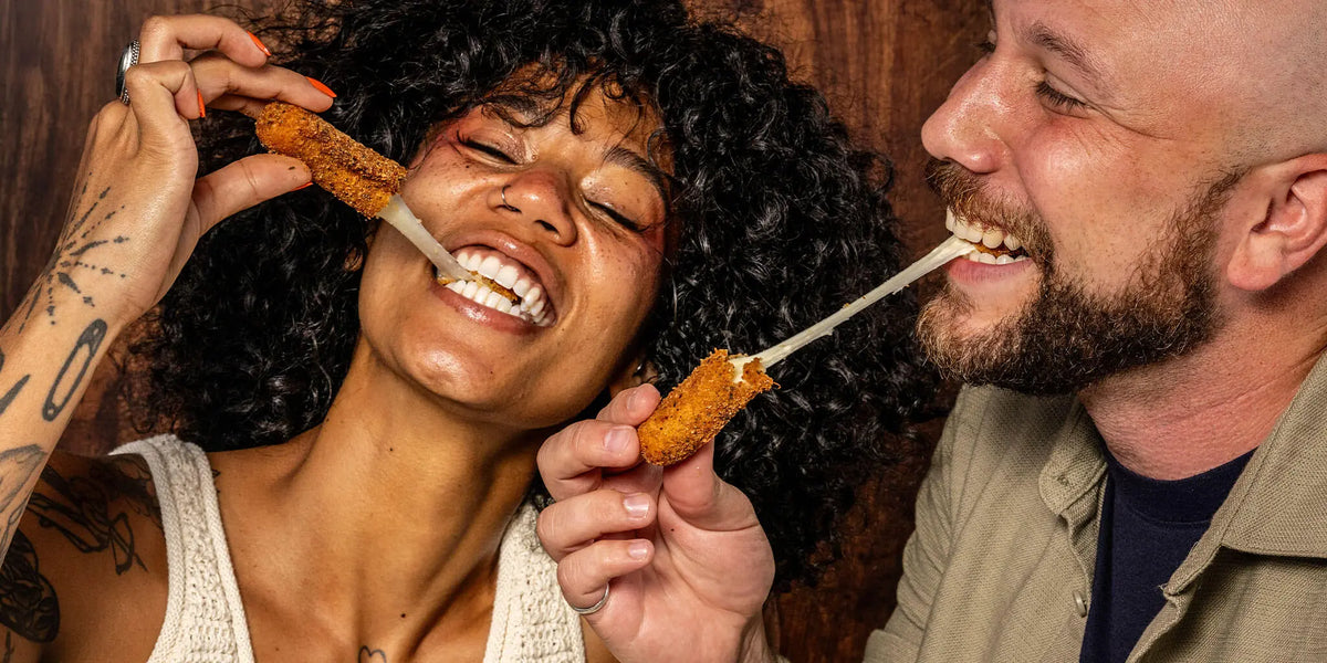Friends enjoying Big Mozz Original Mozzarella Sticks with a cheese pull